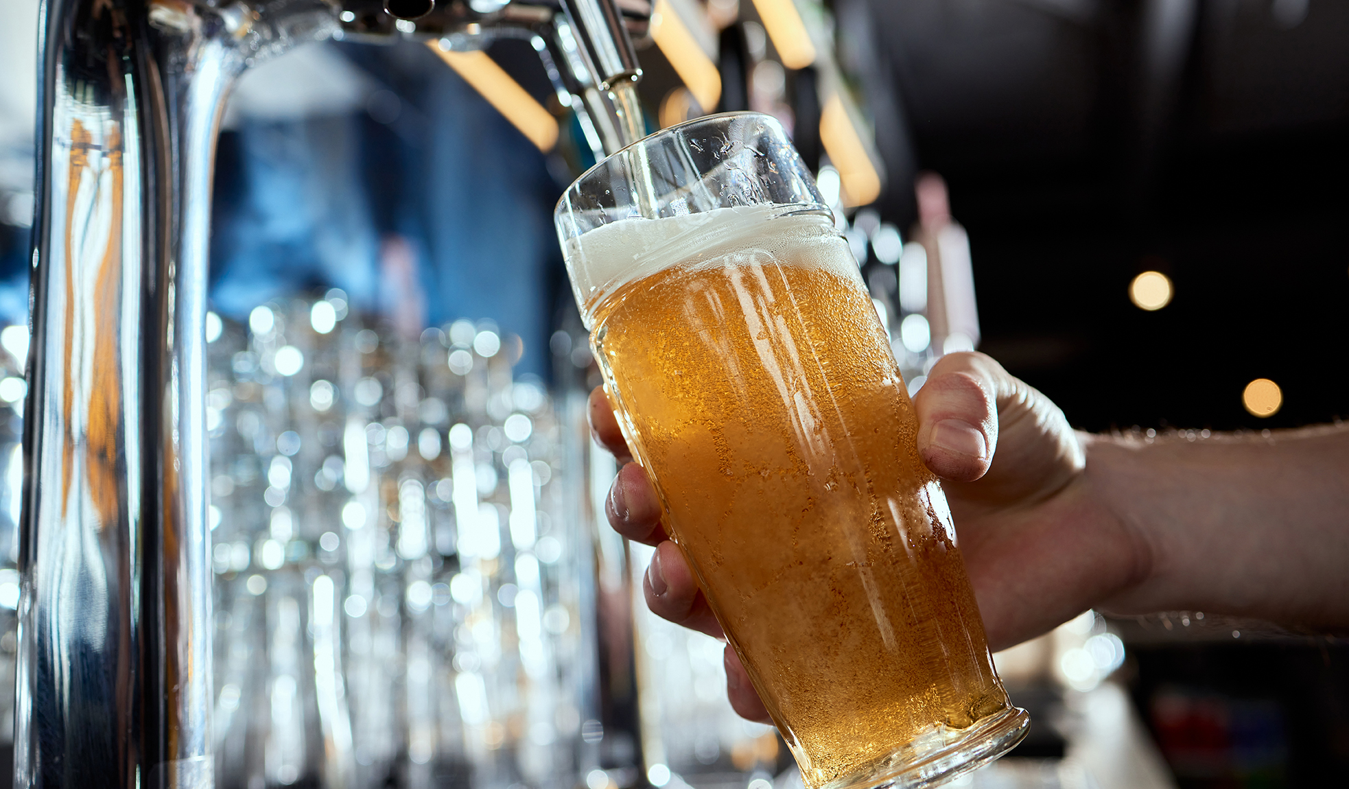 Pouring beer into a mug in a beer bar close-up. Beer bottling in the restaurant. The bar counter.